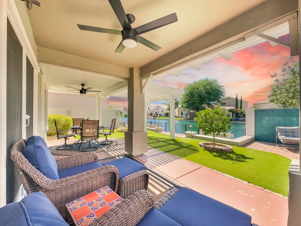 This image showcases an inviting outdoor seating area beside a sparkling swimming pool, with lush greenery and a dining table set for relaxation or entertaining. The tranquil ambiance is enhanced by the gentle lighting and sense of privacy, making it ideal for leisurely afternoons or socializing with neighbors.